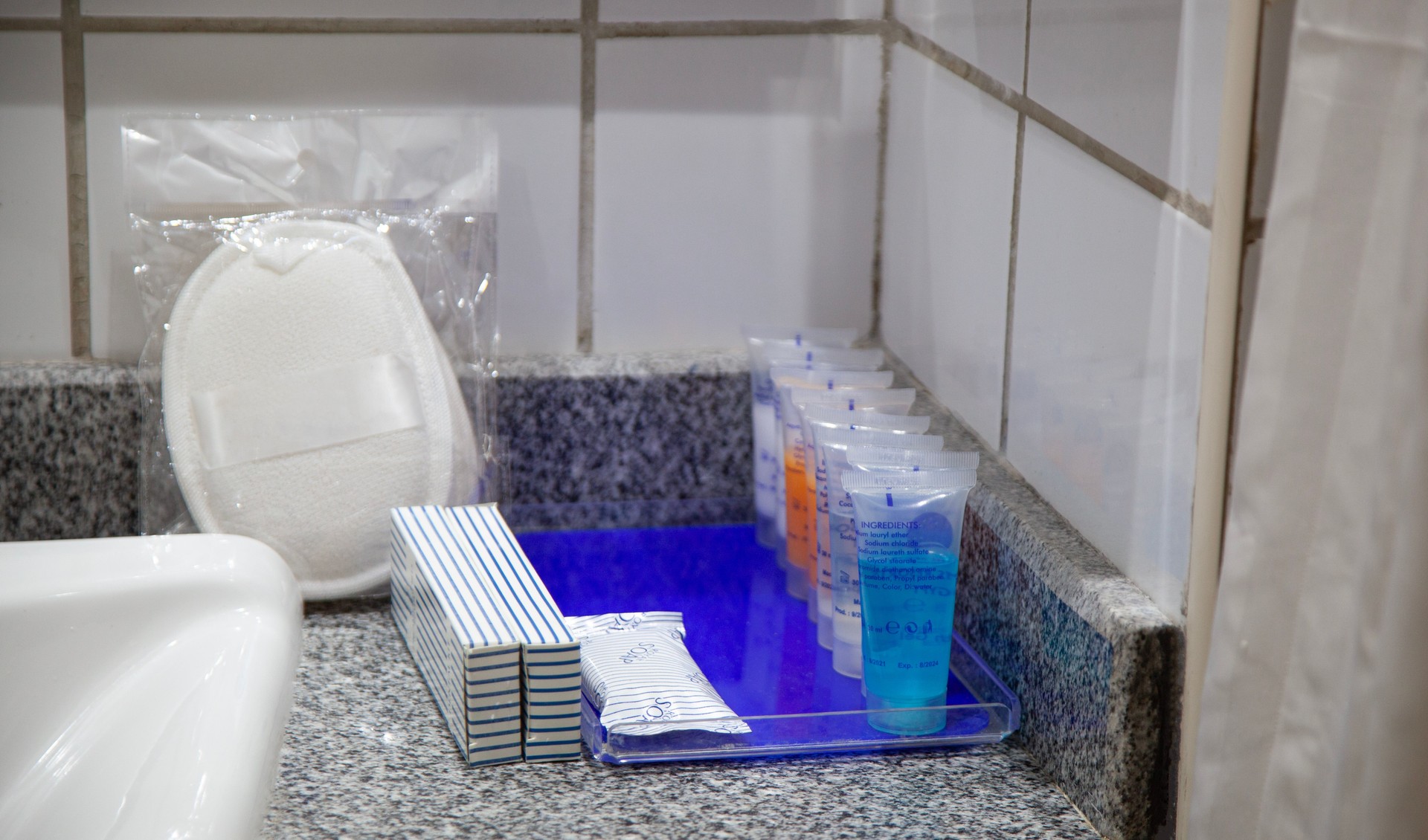 Personal cleaning items and small shampoo bottles in basket in hotel room